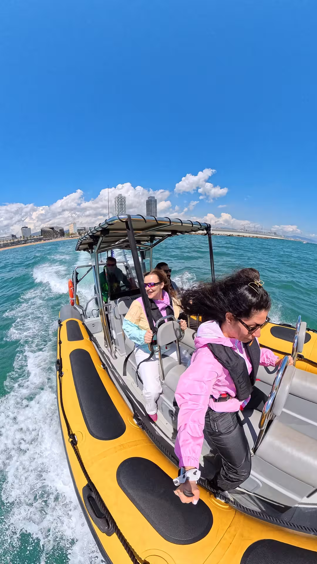 Thrill-seekers enjoy a speed boat adventure on the Mediterranean, with stunning views of Barcelona's skyline under a clear blue sky.
