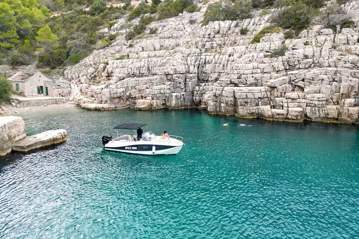 Speedboat in secluded Hvar North Shore cove with rocky cliffs, part of Golden Horn private tour