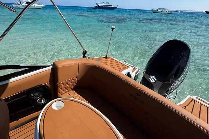 Speedboat seating and swim platform in crystal-clear Red Sea water on private Magawish Island snorkeling trip