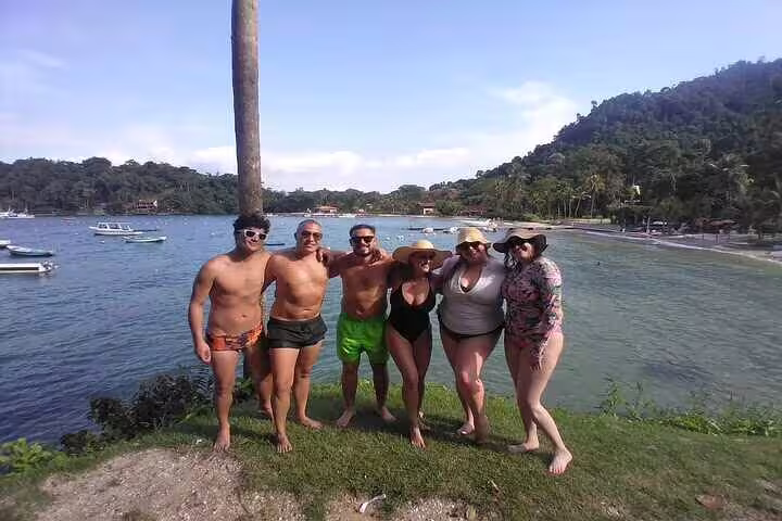 Group of tourists enjoying a scenic view by the beach during a speedboat tour in Angra with Rio pick-up.
