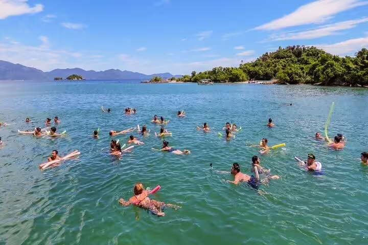 Group of tourists enjoying swimming and snorkeling in the vibrant waters of Angra dos Reis islands.