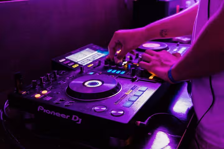 DJ mixing tracks in a vibrant club atmosphere during Split After Dark boat crawl event.
