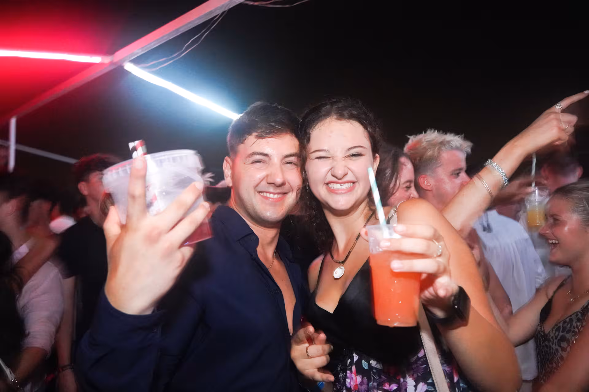 Smiling couple enjoying colorful cocktails on a Split boat crawl, showcasing the vibrant party atmosphere.