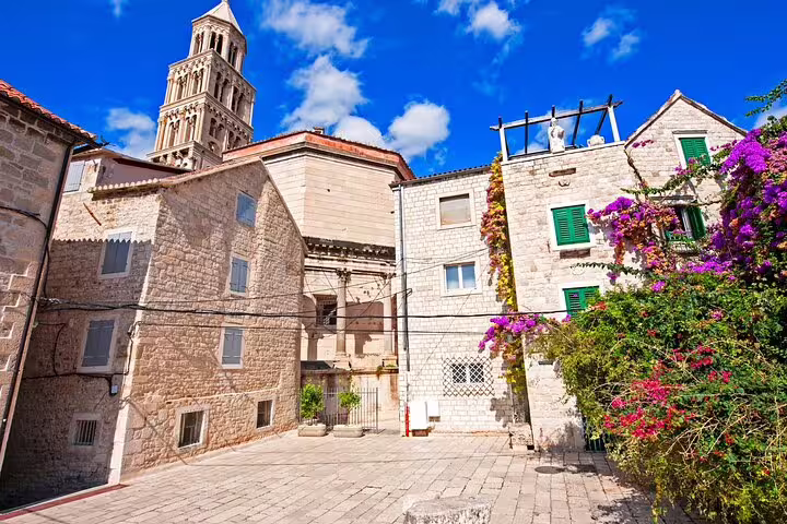 Stone courtyard in Split Old Town with colorful bougainvillea and St Domnius bell tower on self-guided scavenger hunt