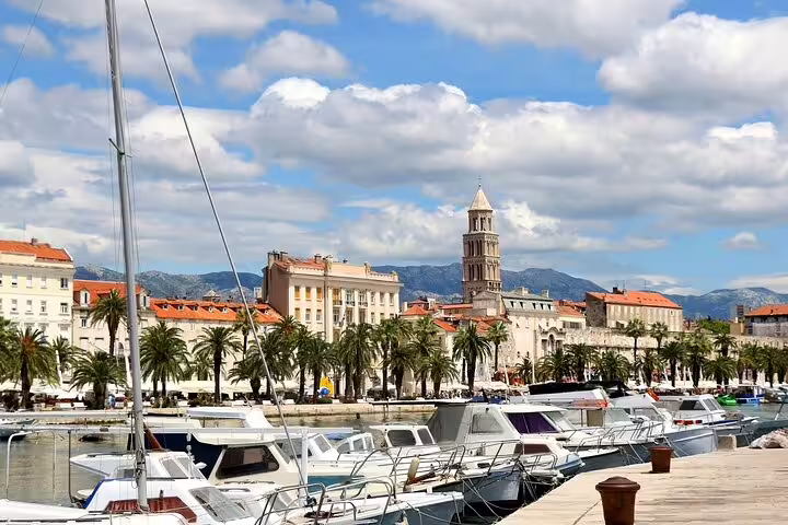 Split Riva promenade marina with boats and Diocletian’s Palace bell tower on a self-guided scavenger hunt