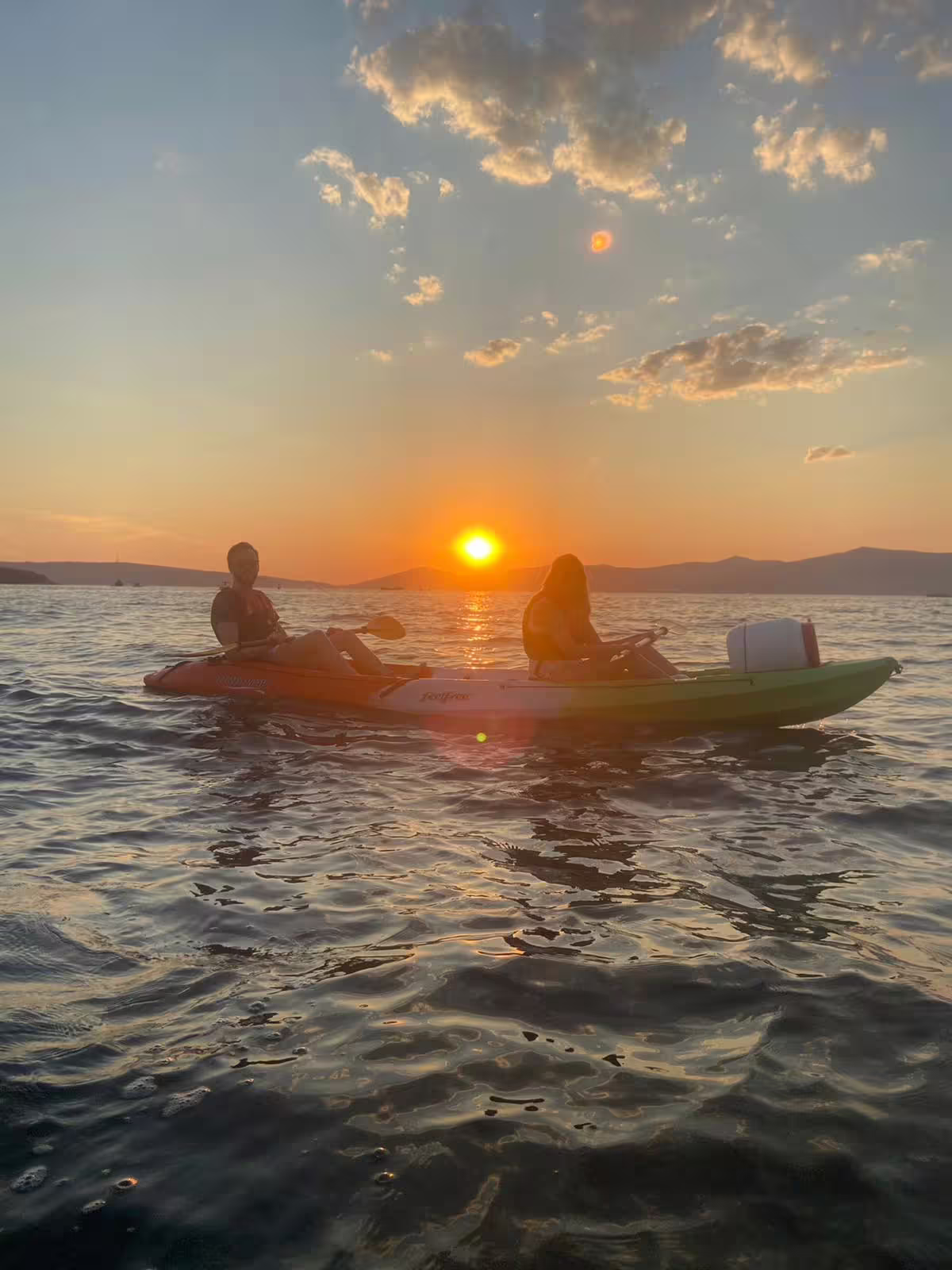 Two kayakers drift on the Adriatic at Split sunset, Croatia, on a sea kayaking tour with wine tasting