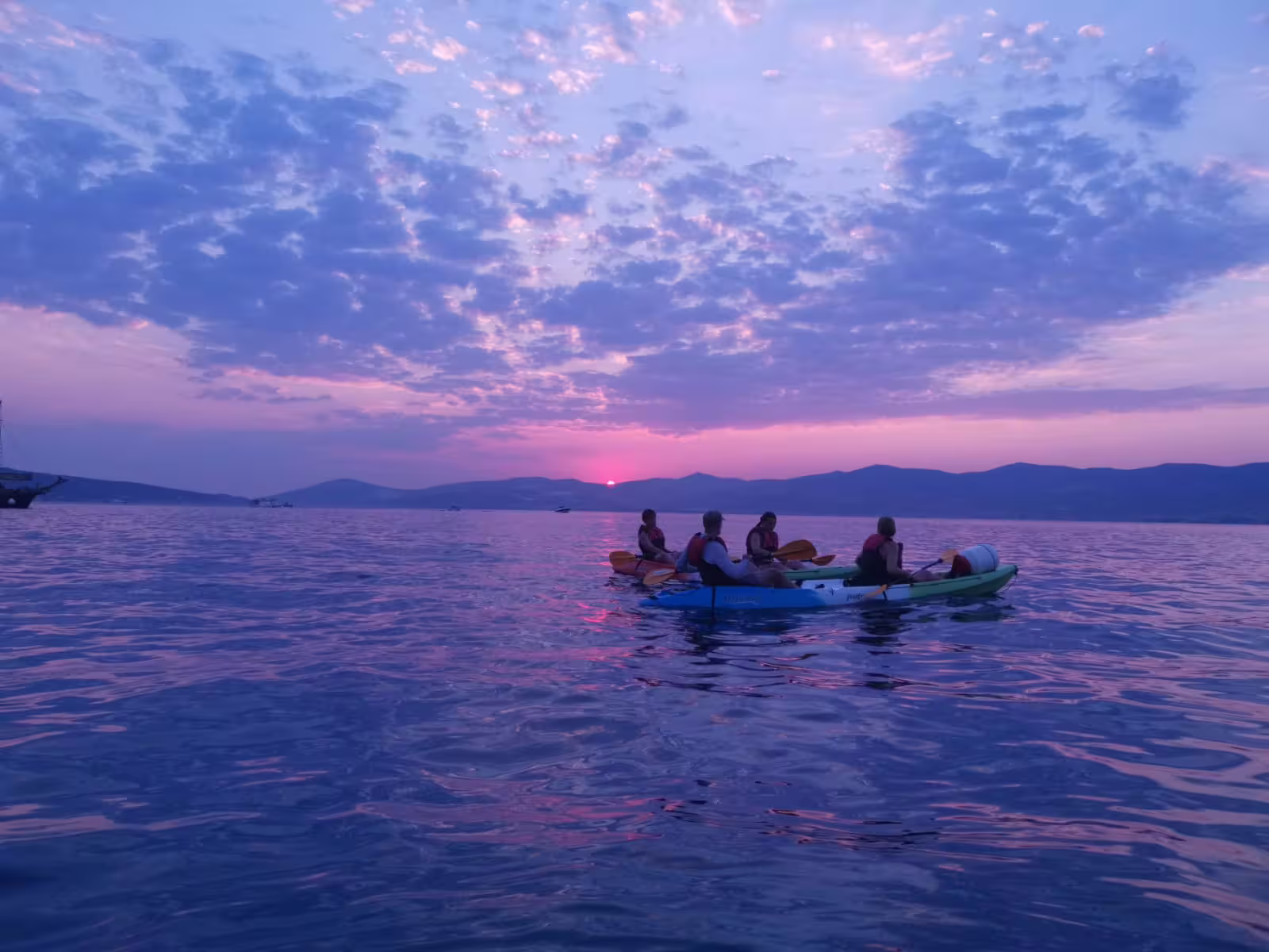 Group sea kayaking at sunset near Split, Croatia, on Adriatic waters with wine tasting on a guided tour