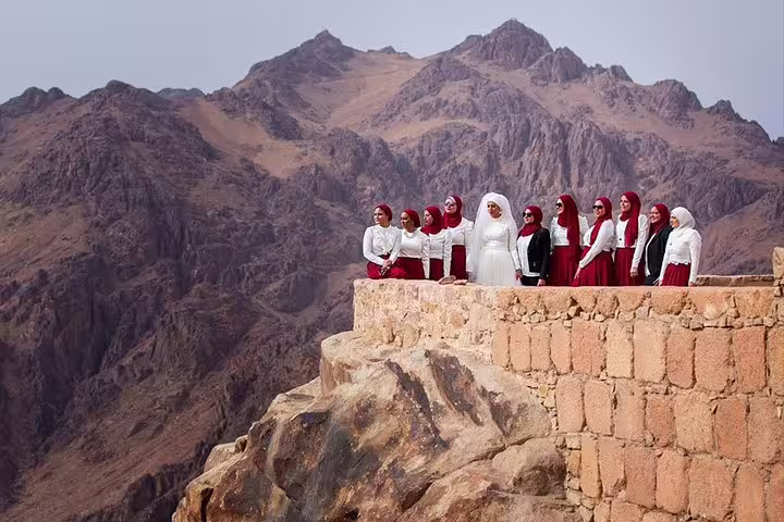 Travelers at St Catherine Monastery viewpoint, Mount Sinai backdrop on overnight Cairo to Sinai tour