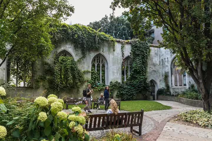 People enjoy a serene moment in the lush garden of St. Dunstan in the East, a hidden gem on a London private tour.