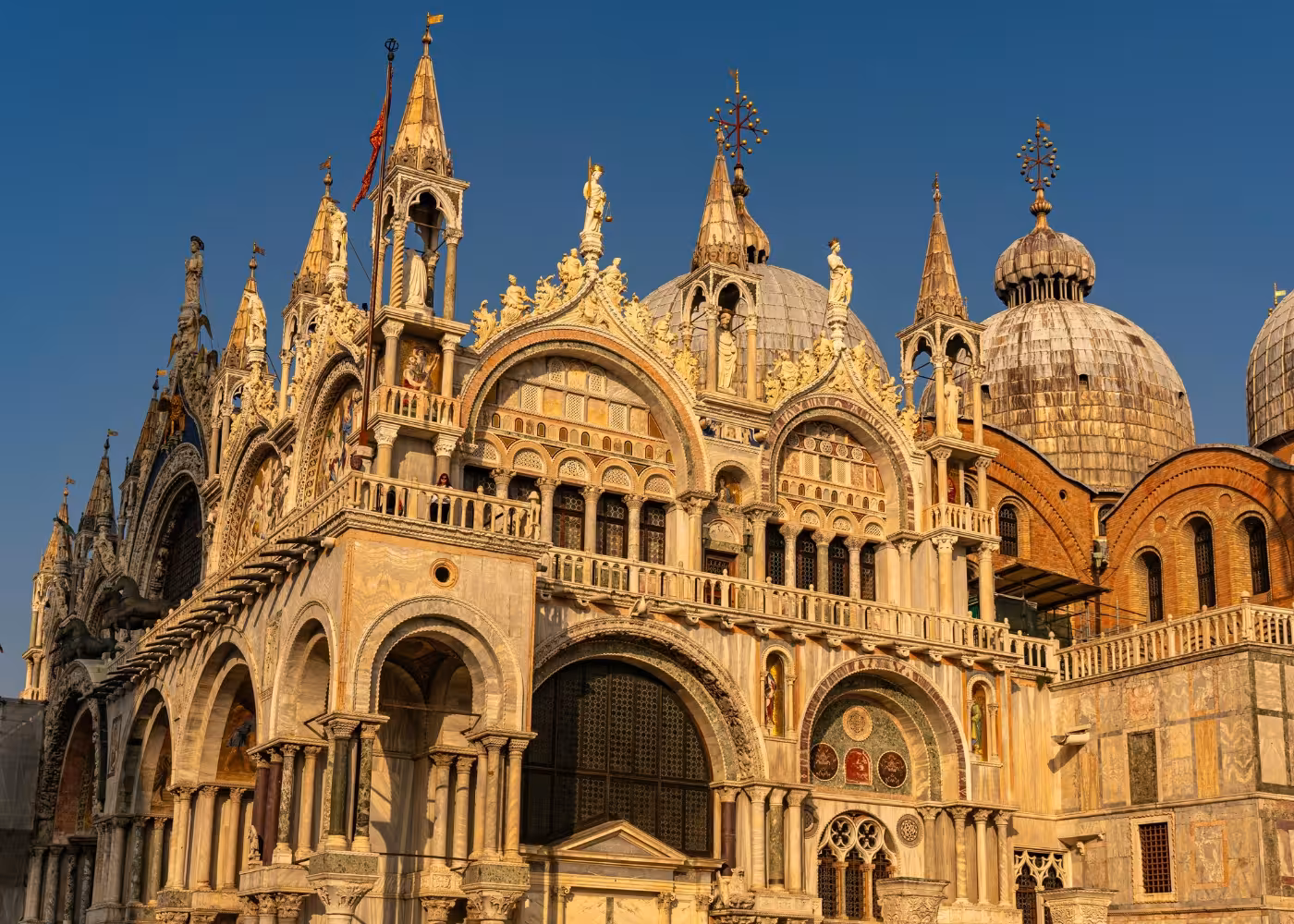Exterior view of St. Mark's Basilica showcasing its stunning Byzantine architecture under a clear blue sky.