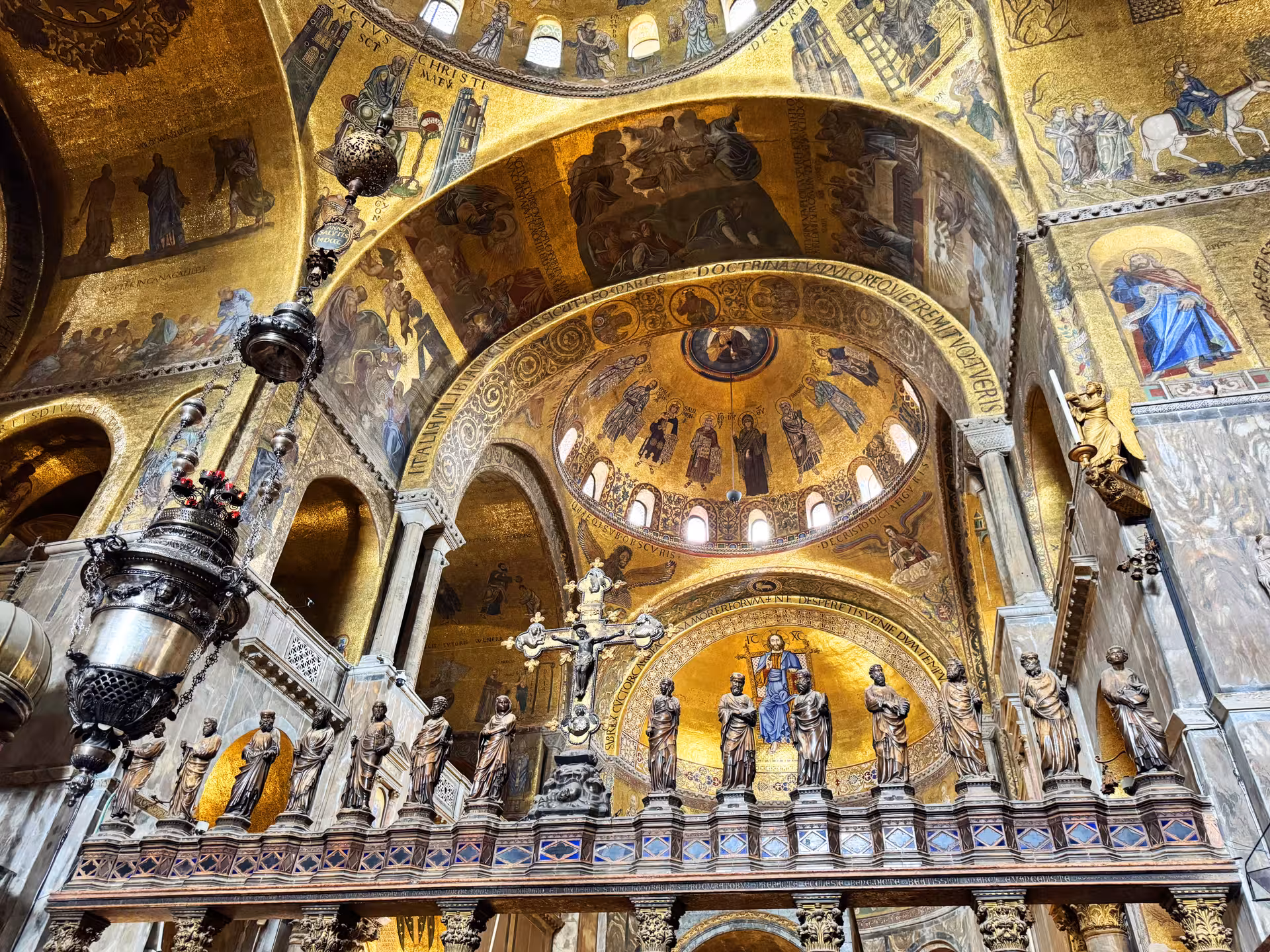 St. Mark's Basilica interior showcasing intricate golden mosaics and religious statues.