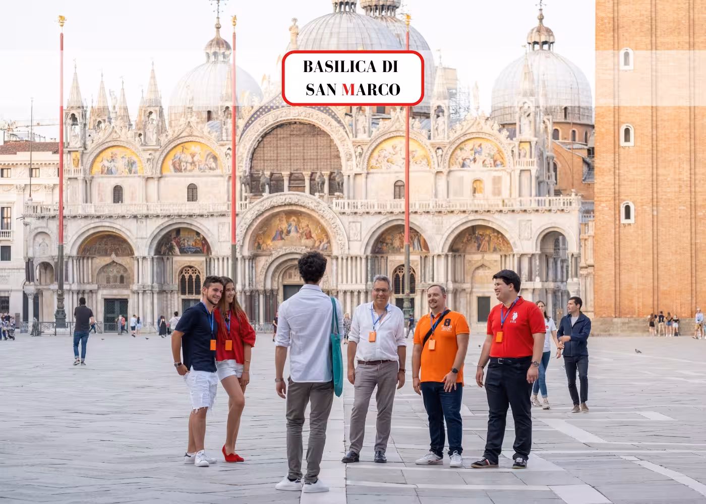 Tourists gather outside St. Mark's Basilica for a guided tour in Venice's iconic square.