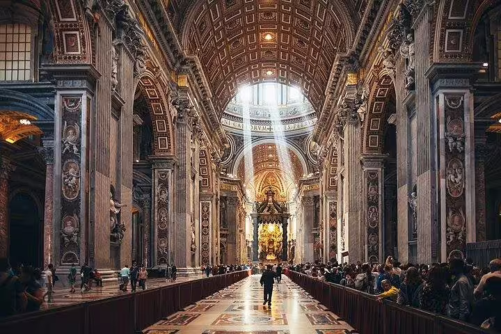 Sunlit nave of St Peter’s Basilica with visitors exploring ornate interiors on a Rome Vatican and dome combo tour