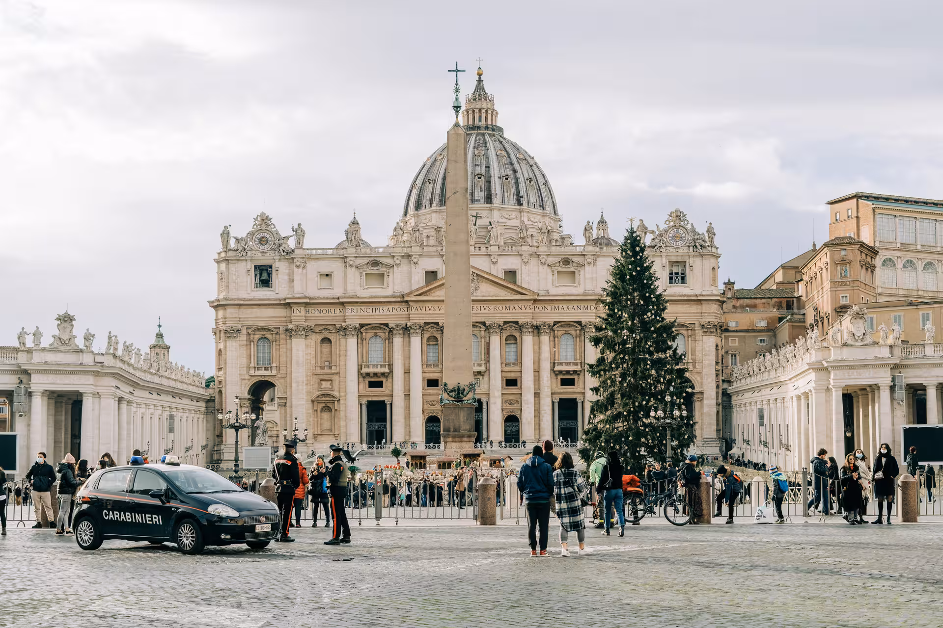 St. Peter's Basilica in Vatican City bustling with visitors during the Jubilee 2025, featuring a festive Christmas tree.