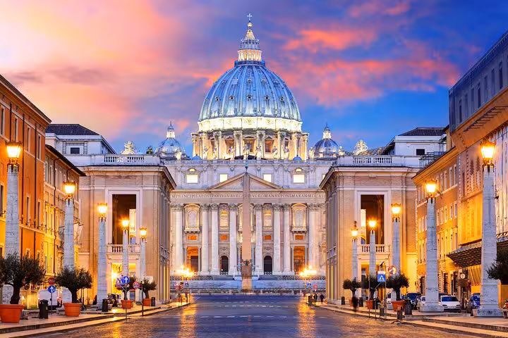Illuminated St. Peter's Basilica at sunset, showcasing Vatican City's iconic architecture for skip-the-line tours.