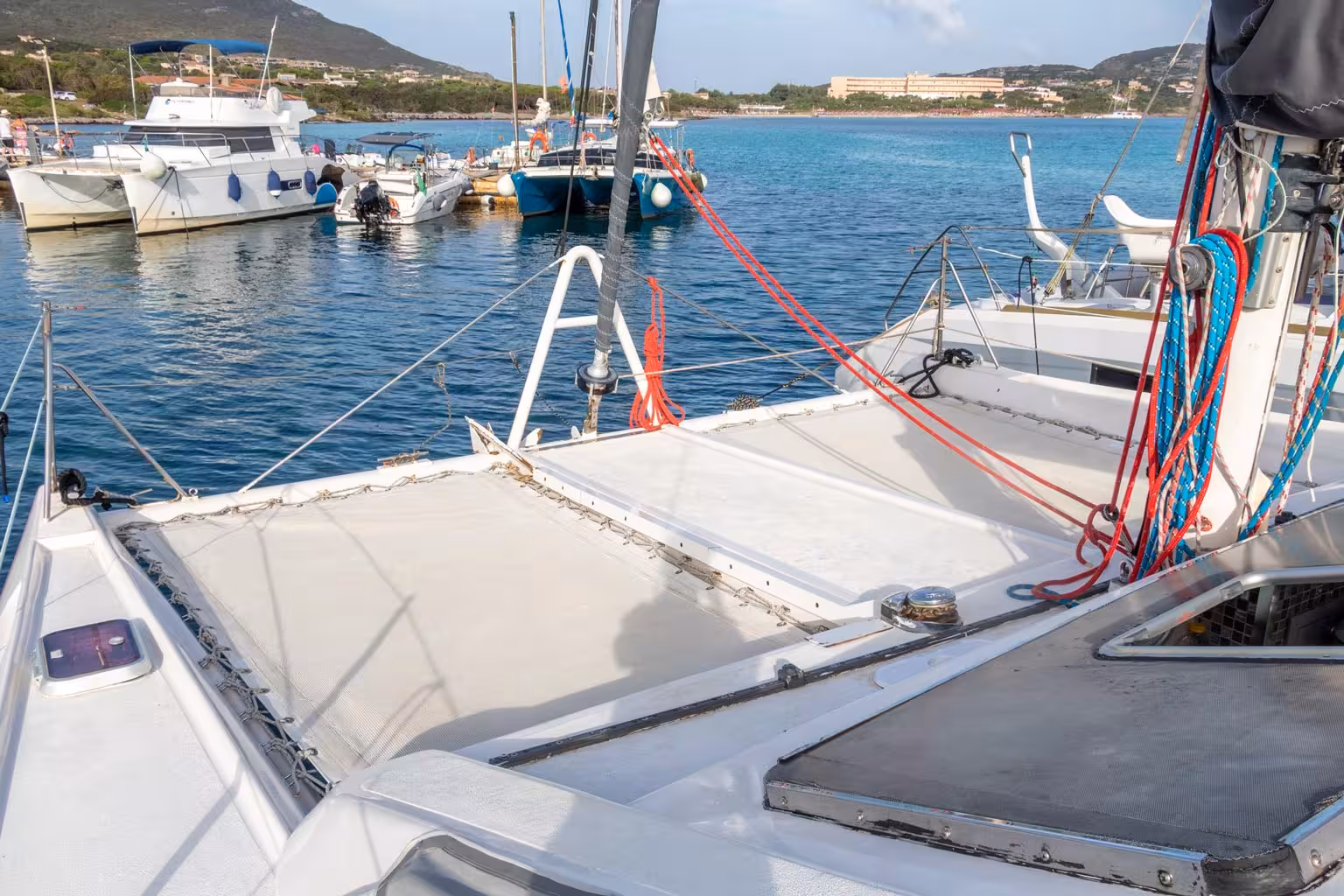 Catamaran deck in Stintino harbor, ready for Asinara Island tour with scenic views of clear blue waters.