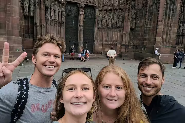 Friends selfie at Strasbourg Cathedral during a scavenger hunt walking tour of city highlights and landmarks