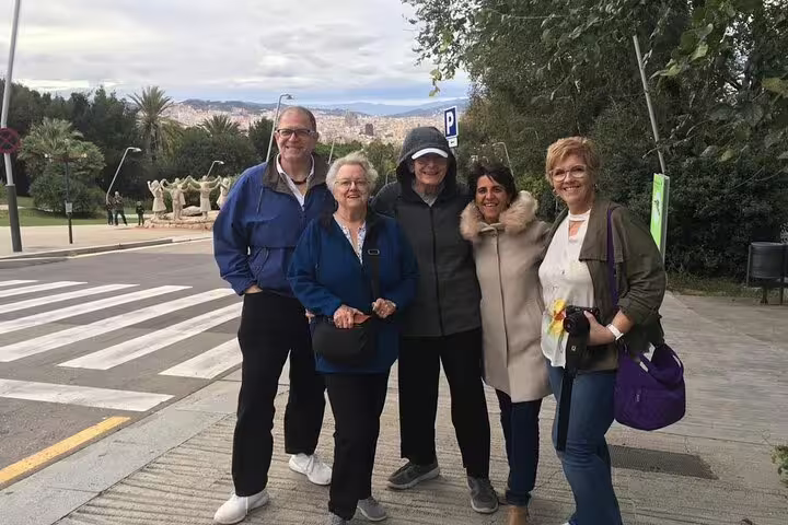 A group of tourists smiles on a scenic street in Igualada, ready for their balloon riding adventure.