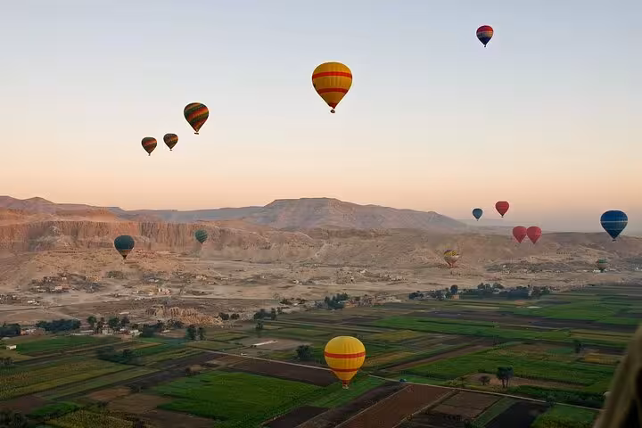 Sunrise hot air balloon over Luxor West Bank and Nile farmlands on private overnight tour from Hurghada