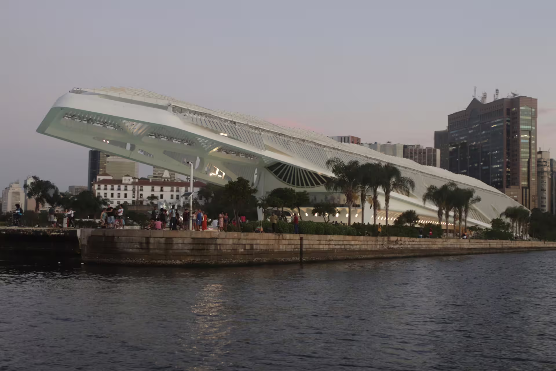 Sunset view of Rio's futuristic Museum of Tomorrow with waterfront and city skyline.