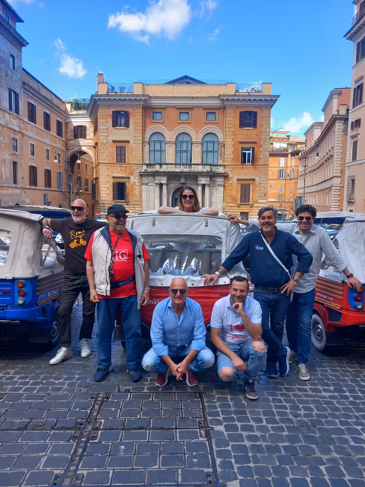 Group of tourists enjoying a vibrant Rome street scene with vintage tuk-tuks during the Sunset in Rome Combo Tour.
