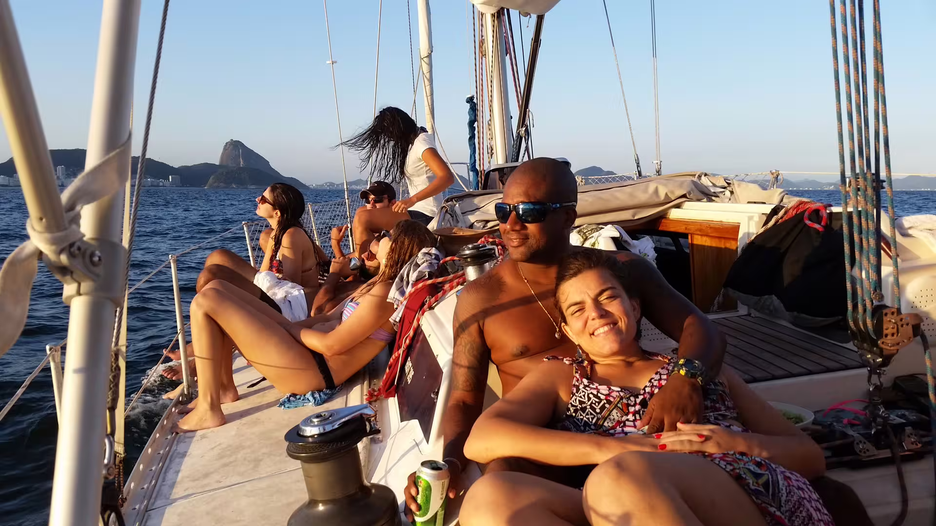 Group enjoying a relaxing sunset sail in Rio de Janeiro with scenic views of Sugarloaf Mountain.
