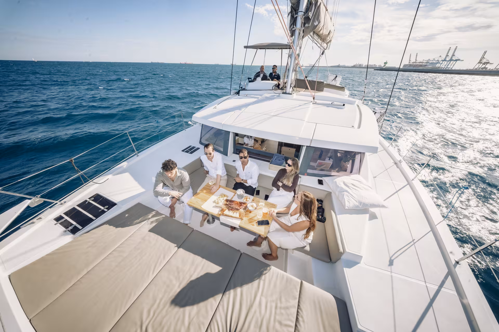Guests dining on a catamaran at sea, ideal pairing with a Sushi Masterclass and waterfront foodie experience