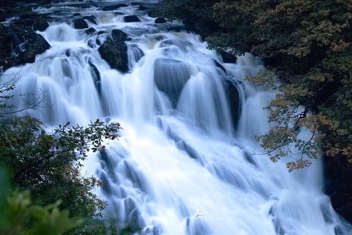 Swallow Falls style cascading waterfall in Snowdonia National Park, scenic stop on Portmeirion tour