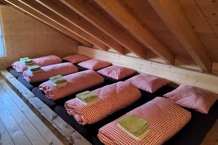 Cozy Swiss alpine hut dorm beds for 4-day trekking tour Swiss Magic Through the Alps, shared lodge stay