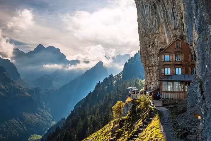 Charming Swiss mountain inn nestled on a cliff, with panoramic views of the stunning alpine landscape.