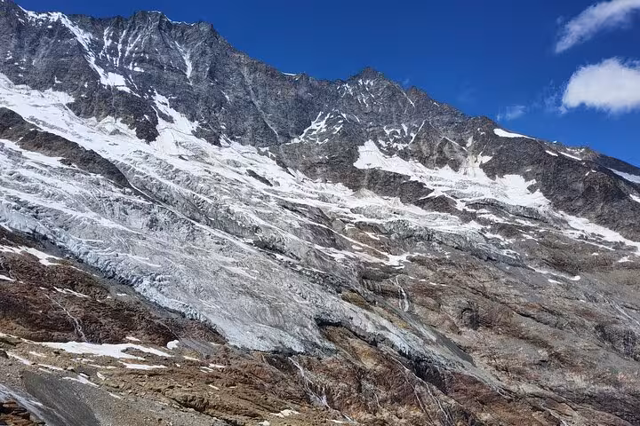 Glacier-streaked Swiss Alps mountain face under blue sky, scenic highlight on Zermatt and Jungfrau tour