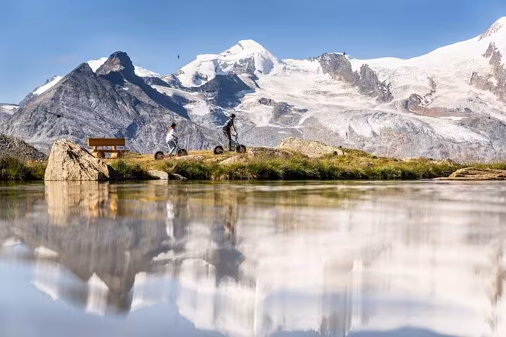 Alpine lake reflection with hikers, snowy peaks and glaciers on Swiss Alps day trip from Zurich Airport