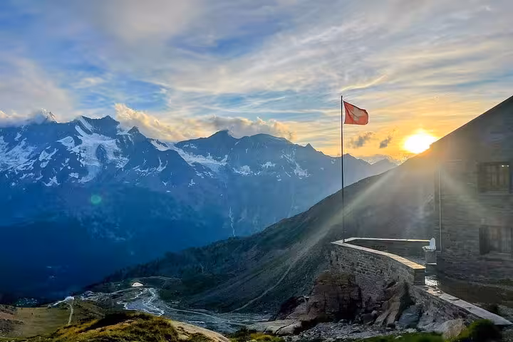 Swiss flag at sunset over Bernese Alps viewpoint, scenic stop on Zurich Airport to Jungfrau hidden gems tour