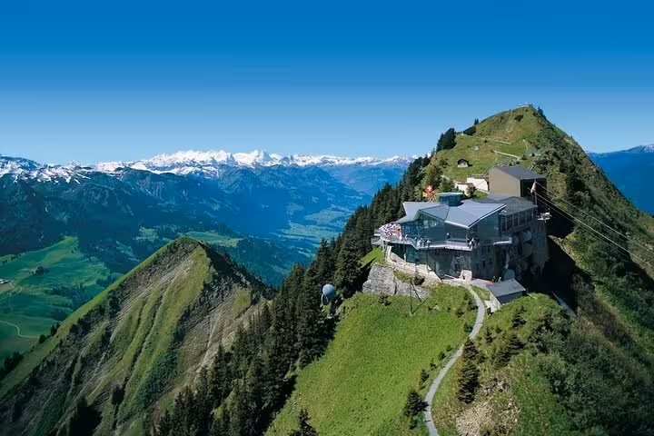 Scenic aerial view of a Swiss mountain lodge with panoramic views of the Alps, ideal for a personalized guide tour.