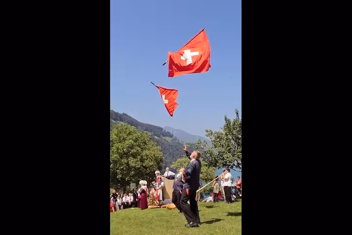 Experience Swiss culture with traditional flag throwers against a backdrop of stunning alpine scenery.
