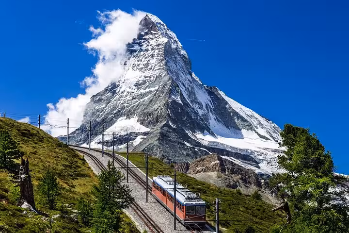 Scenic Swiss train journey by the Matterhorn, showcasing the beauty of Switzerland's iconic alpine landscape.