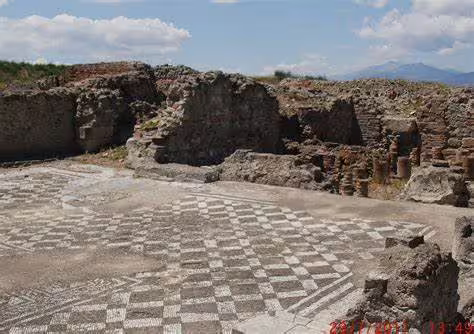Ancient mosaic floor and stone ruins at the archaeological site of Sybaris in Calabria, Italy, under a bright Mediterranean sky