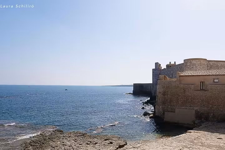 Enjoy breathtaking coastal views of Ortigia Island's historic fortifications on your Syracuse and Noto adventure.