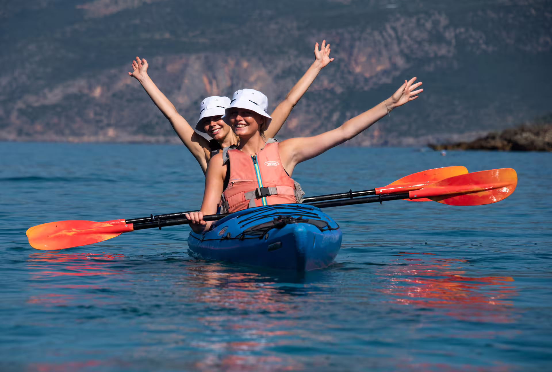 Two women in tandem kayak on clear water near Kardamyli and Stoupa, guided sea kayaking in Mani Greece