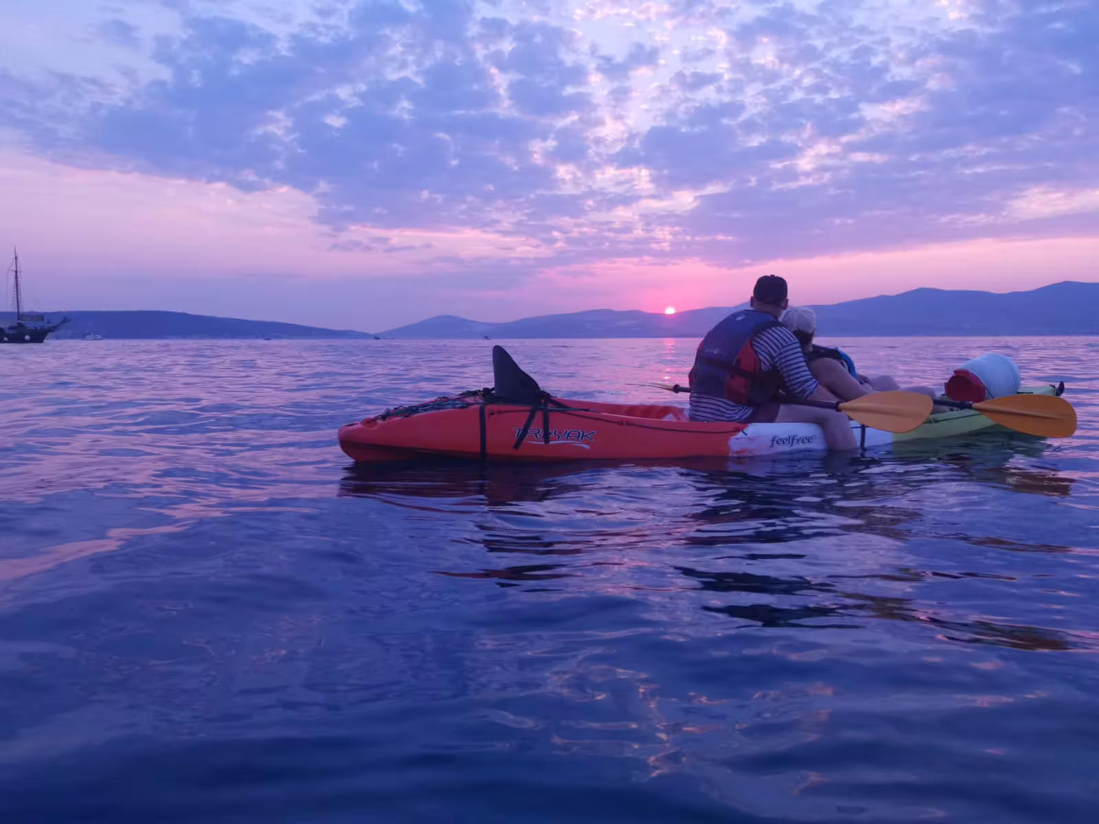 Tandem sea kayak at pink sunset near Split coastline, Croatia, on evening sea kayaking tour with wine