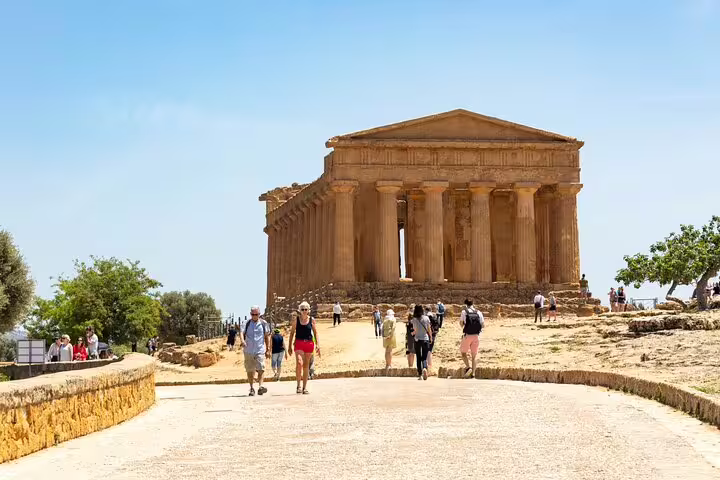 Visitors walking toward the well-preserved Temple of Concordia in Agrigento’s Valley of the Temples on a guided Sicily tour