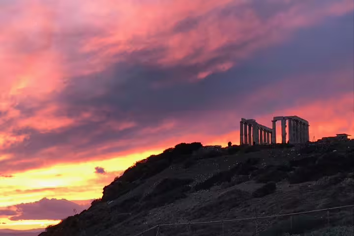 Temple of Poseidon at Cape Sounion glowing at sunset on a small-group half-day tour from Athens