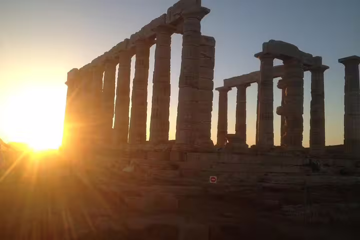 Temple of Poseidon at Cape Sounion glowing at sunset on a small-group half-day tour from Athens
