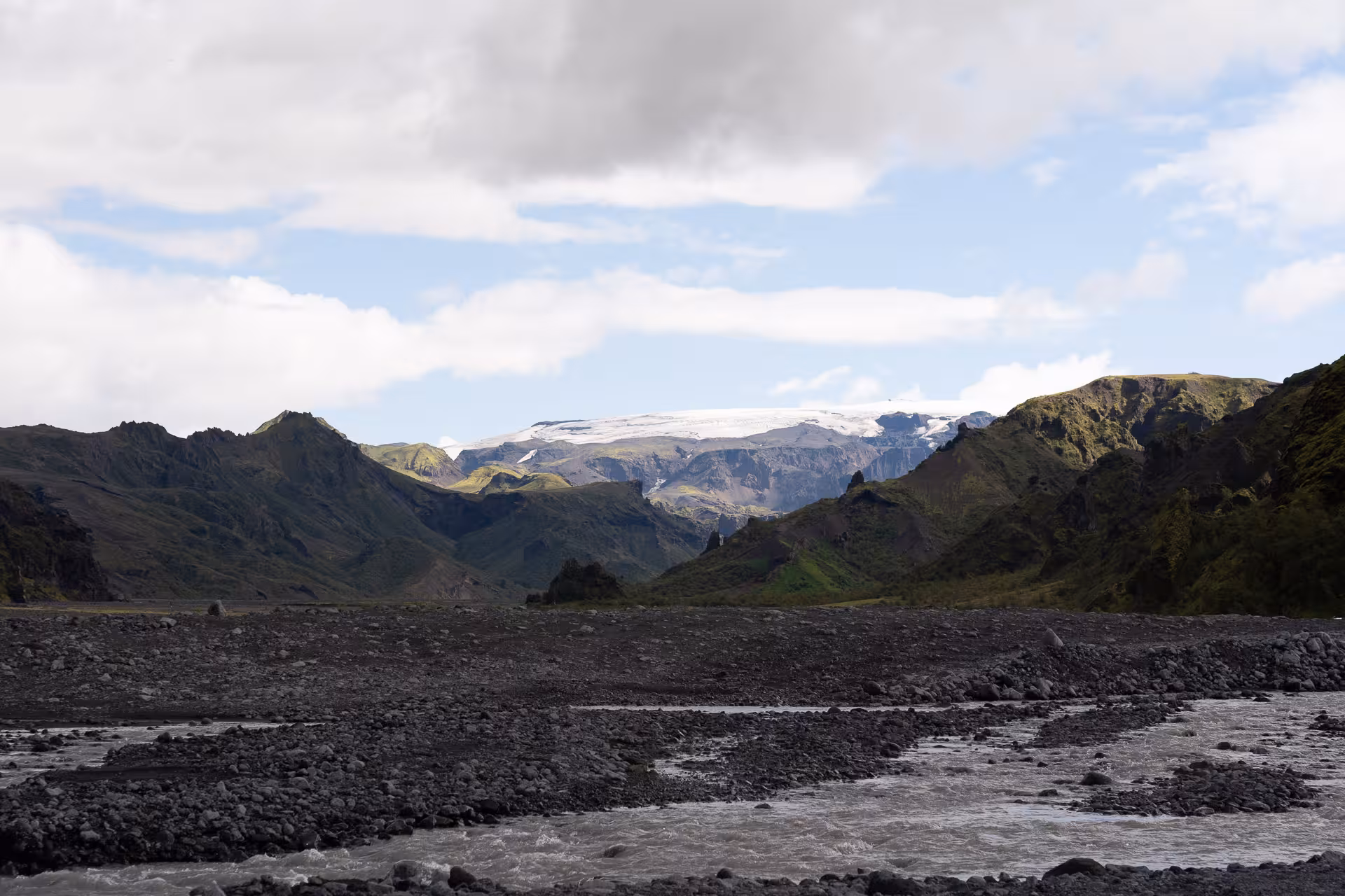 Glacial river crossing in Þórsmörk with rugged highland mountains and ice cap backdrop on private off-road tour