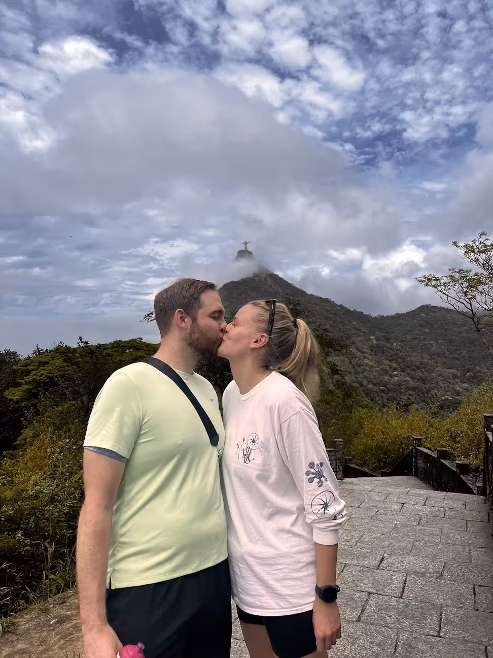 Couple at Tijuca Forest viewpoint with Christ the Redeemer in clouds, a scenic stop on Rio rainforest bike tour