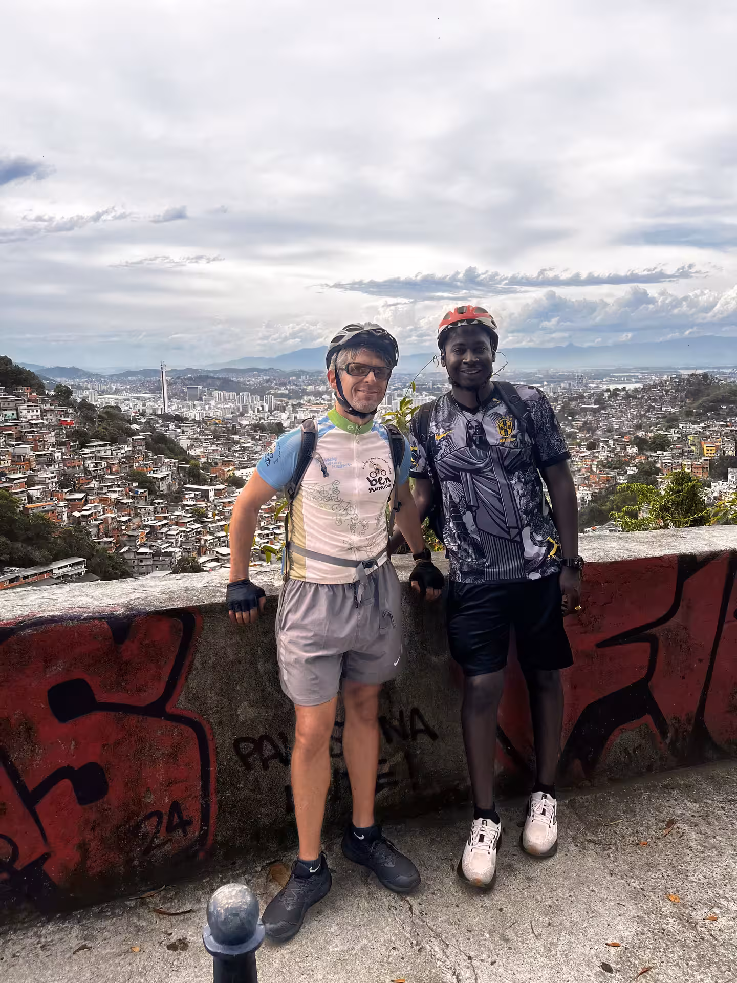 Cyclists in helmets pose at a Rio de Janeiro viewpoint during Tijuca Forest mountain bike rainforest adventure