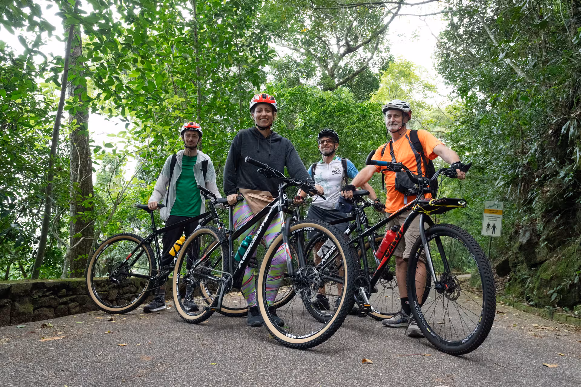 Group of riders with mountain bikes pause on a Tijuca Forest trail in Rio de Janeiro rainforest adventure