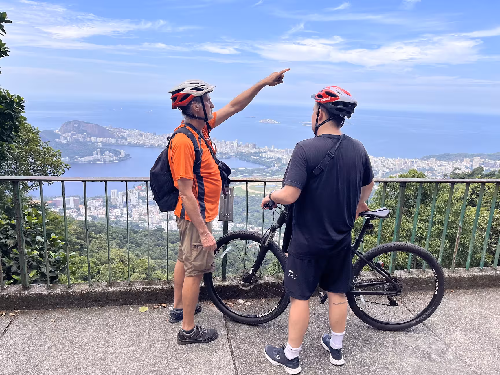 Cyclists at Tijuca Forest viewpoint overlooking Rio de Janeiro and Guanabara Bay on a mountain bike tour