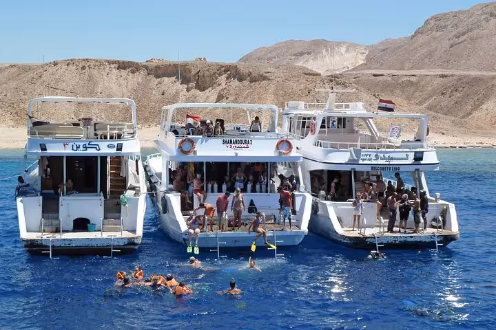 Snorkel boats anchored near Tiran Island, Red Sea, on a full-day Sharm El Sheikh boat trip with reef stops