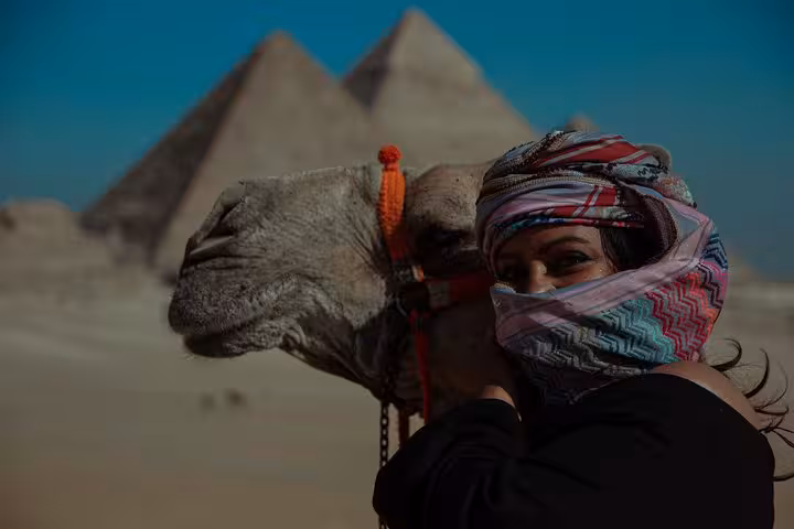 Tourist with camel at Giza Pyramids, Cairo private guided tour photo stop in the desert
